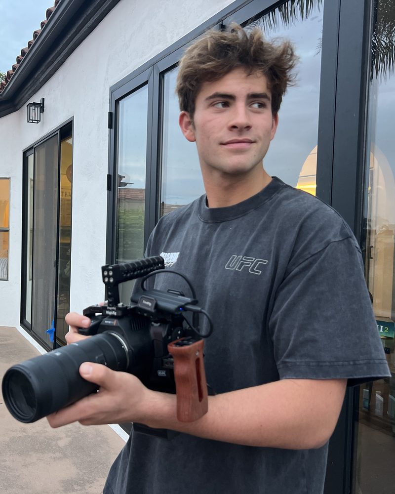 Jackson holding a rigged Blackmagic camera on a patio at dusk